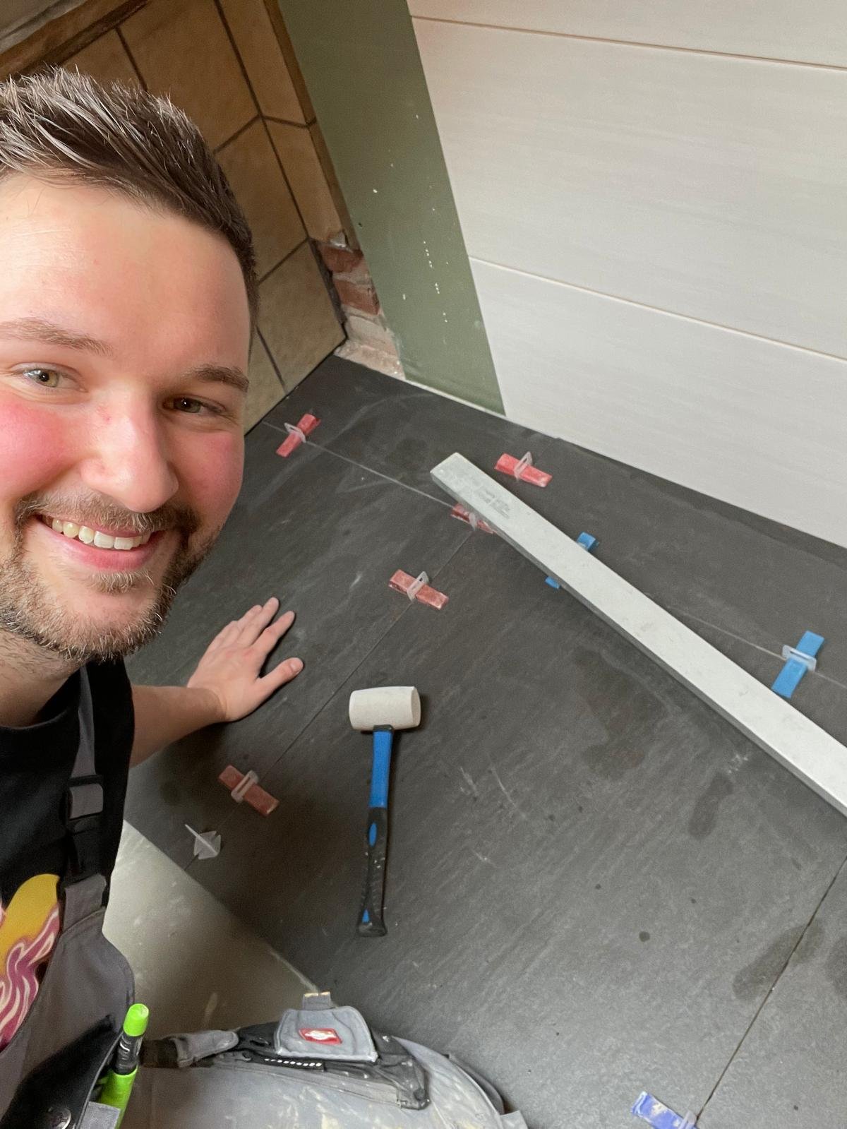 Dennis Damaschek bei der Arbeit als Fliesenleger
